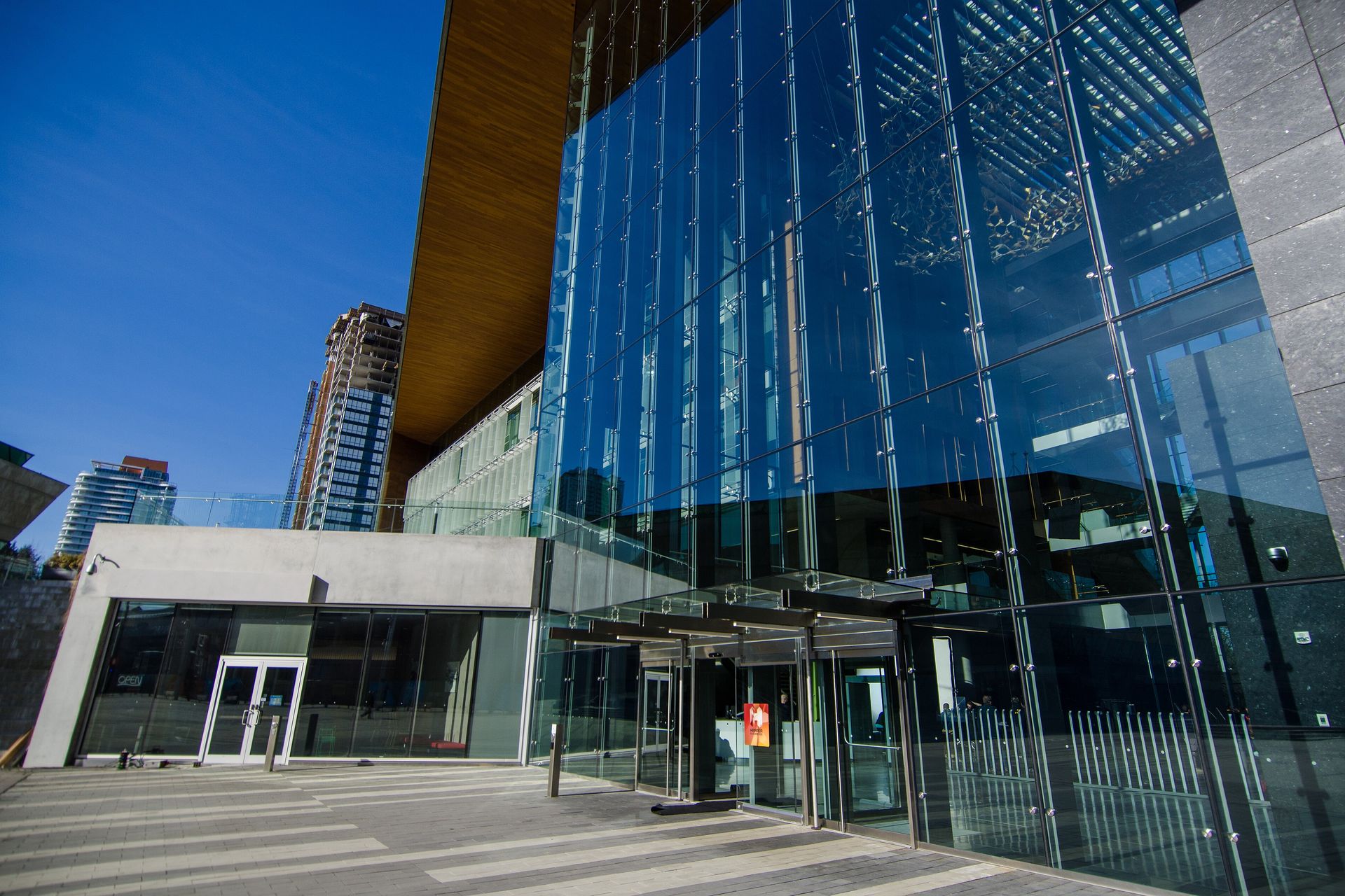 Glass entrance of Surrey City Hall beside City Centre towers