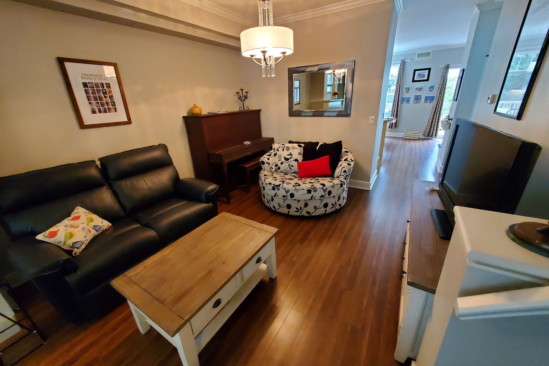 Living room of a South Surrey home with a sofa, piano and laminate floors