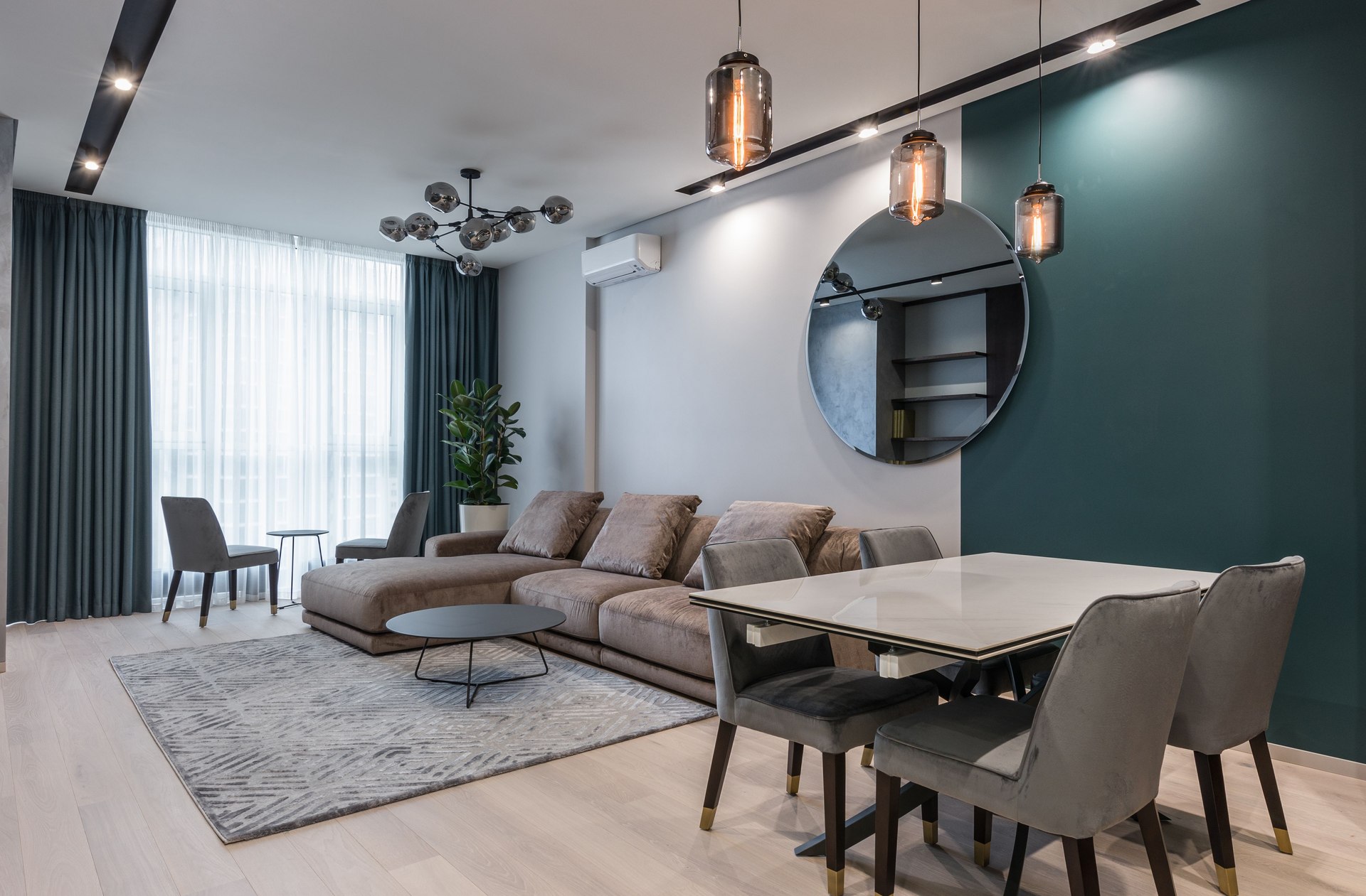 Contemporary living and dining room with a teal feature wall