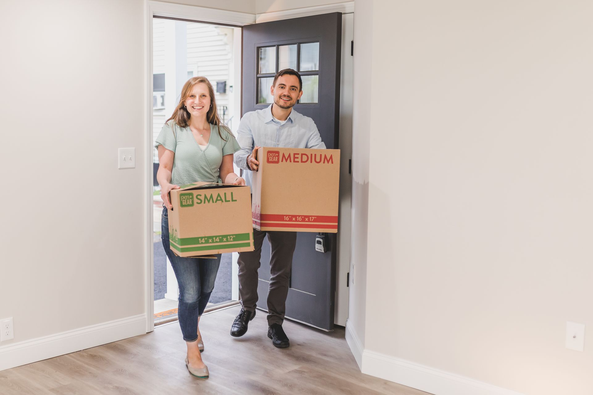 A couple carrying boxes into their new home; illustrative stock photograph